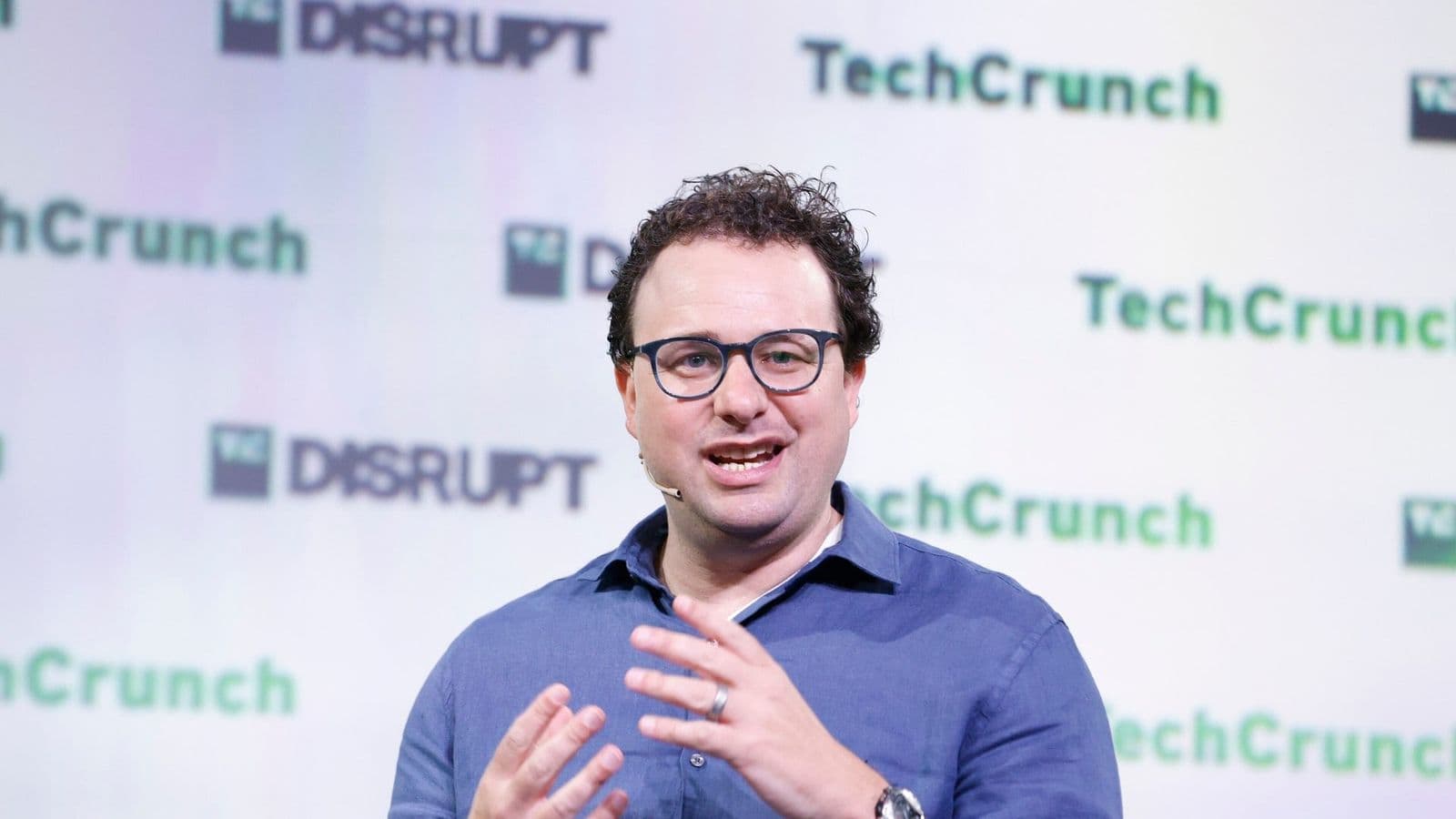 Dario Amodei puhuu lavalla TechCrunch Disrupt 2023 -tapahtumassa ja elehtii käsillään