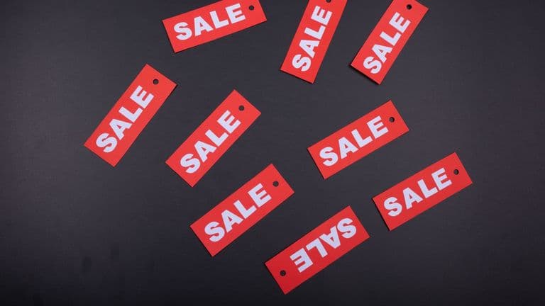Punaisia SALE-hintalappuja hajallaan tummalla taustalla