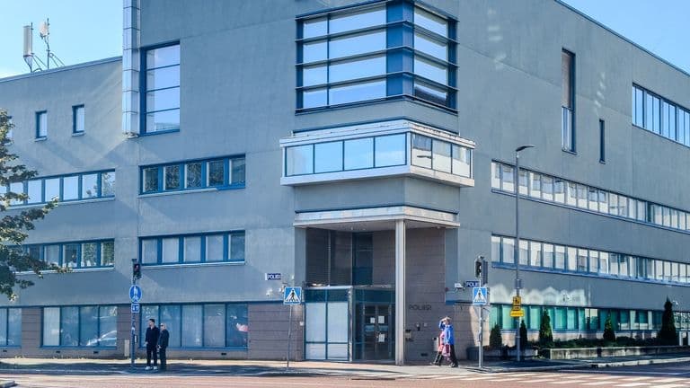 Poliisitalon kulma ja sisäänkäynti Jyväskylässä, edessä jalankulkijoita suojatien lähellä