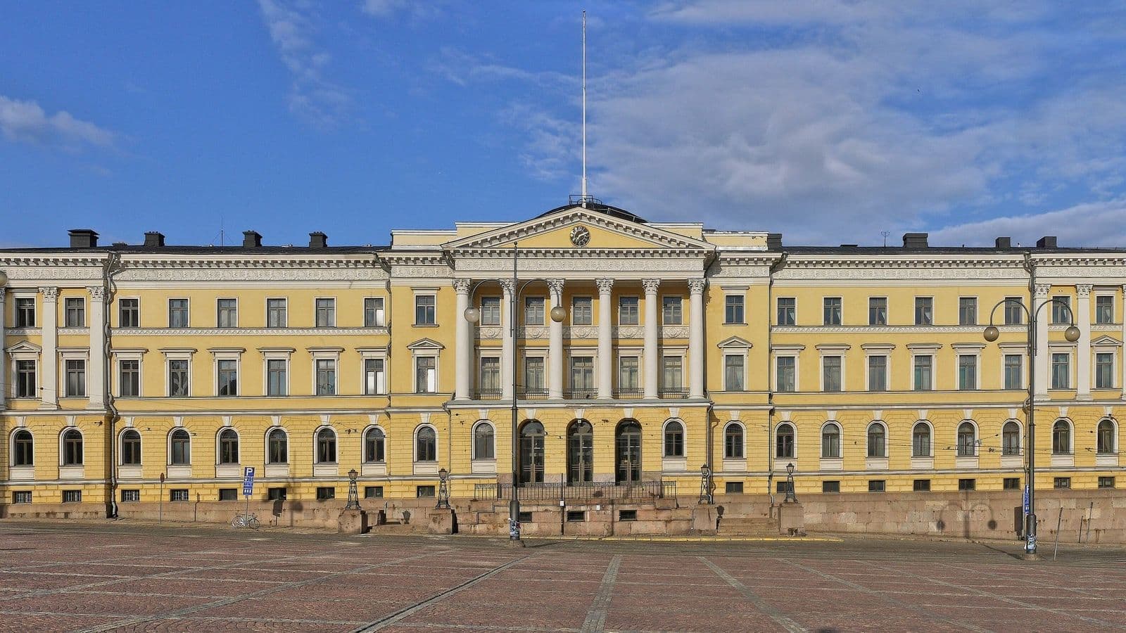 Valtioneuvoston linna Helsingin Senaatintorilla keltaisine julkisivuineen sinistä taivasta vasten