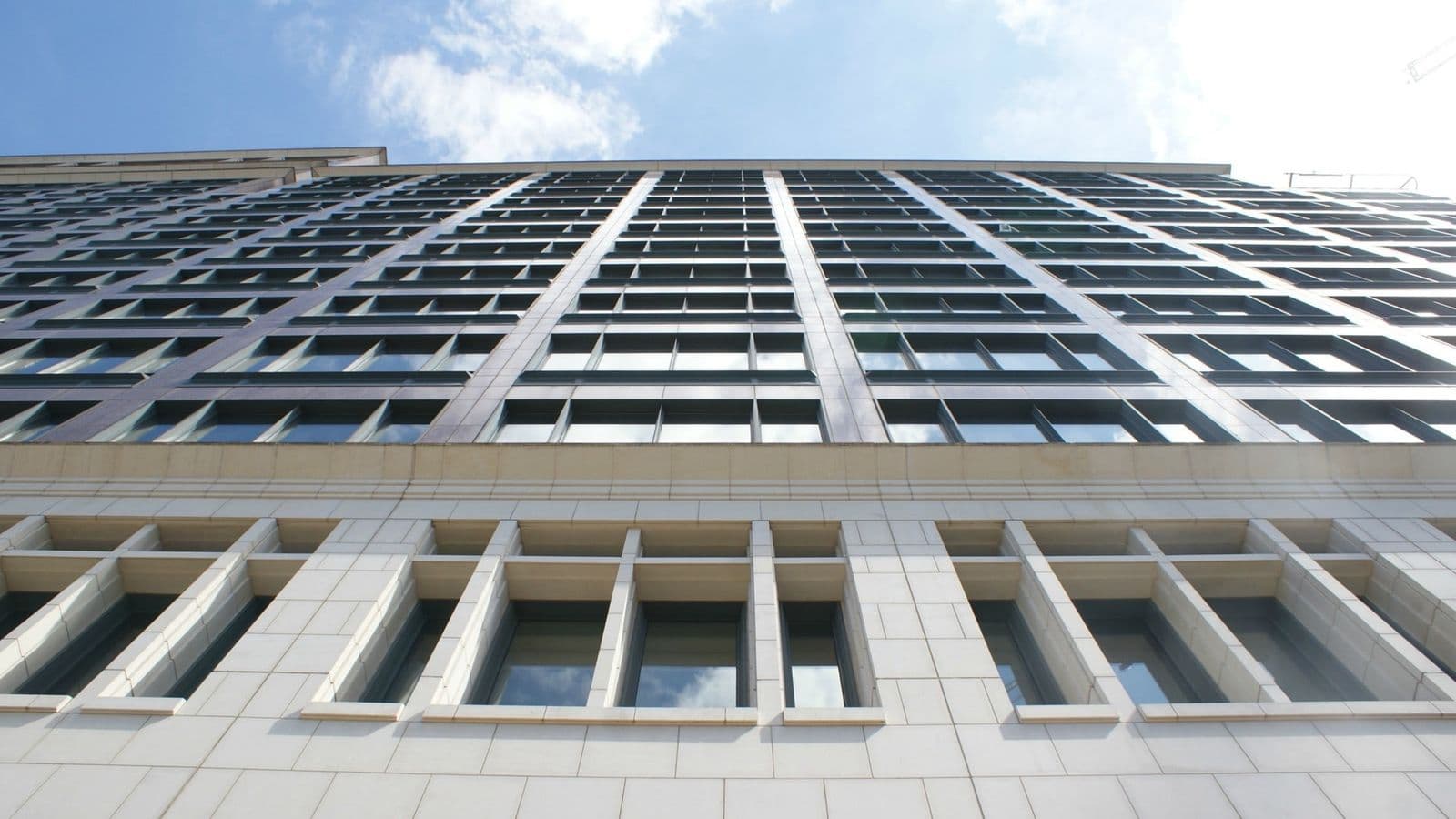 Morgan Stanleyn toimistorakennus Canary Wharfissa kuvattuna alhaalta ylöspäin sinistä taivasta vasten