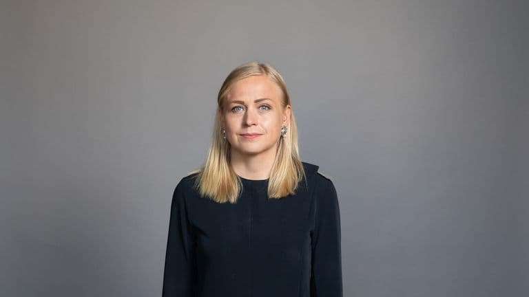 Ulkoministeri Elina Valtonen tummassa puvussa harmaata taustaa vasten studiomuotokuvassa