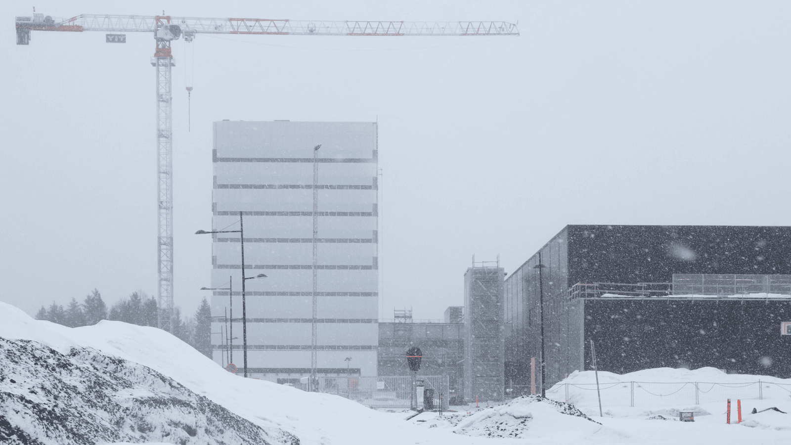 Nokian uuden kampuksen rakennuksia ja nostokurki lumisateessa Oulun Linnanmaalla.